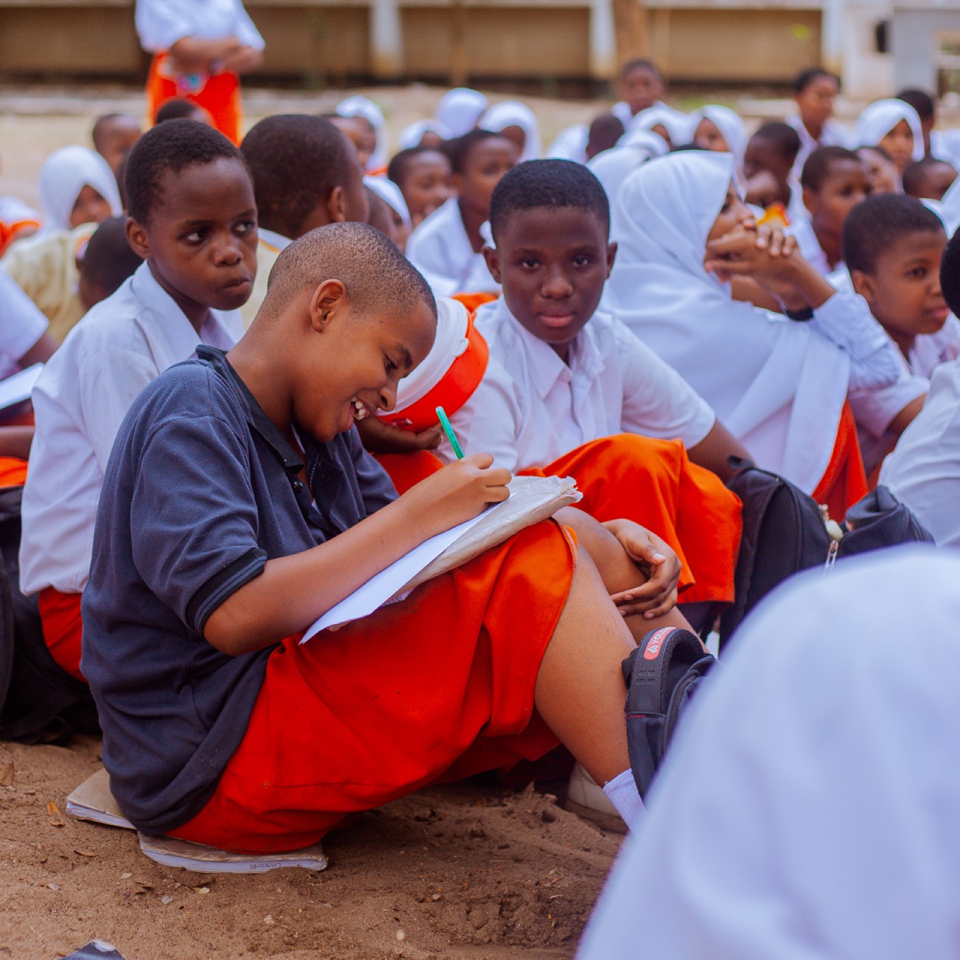 A student smiles while taking notes during the outreach session