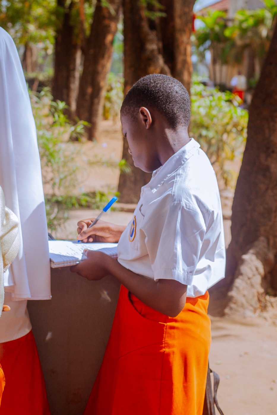 A student carefully writes notes during the session