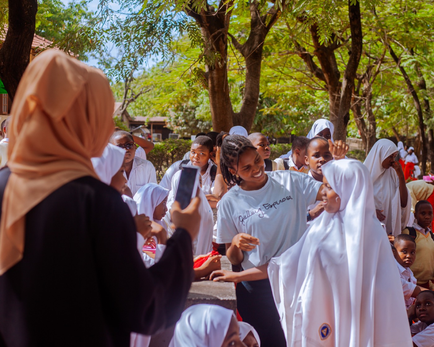A GROW team member captures a joyful moment with students nearby