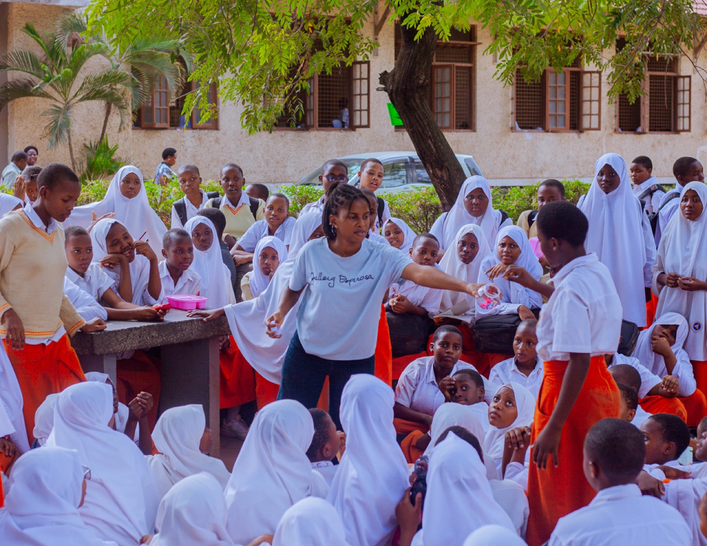 A GROW team member shares an energetic moment with cheering students